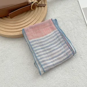 Detail shot of light blue striped linen scarf with color block on soft textured background