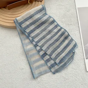 Detail of blue and beige striped linen scarf with fine overlock stitching on soft texture