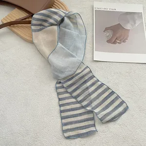 Detailed texture of slim linen striped scarf with blue and white blocks on leather bag