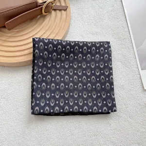 Retro geometric pattern square scarf with lace trim on a minimalist wooden display base