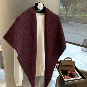 Detailed texture of burgundy wool knit shawl paired with a white long-sleeved shirt