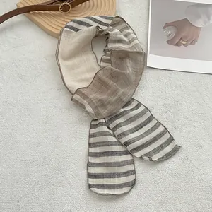 Macro detail of breathable striped linen scarf with fine stitched edges in French style