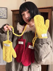 Détail de moufles en maille torsadée avec cordon de cou en couleurs jaune et rouge