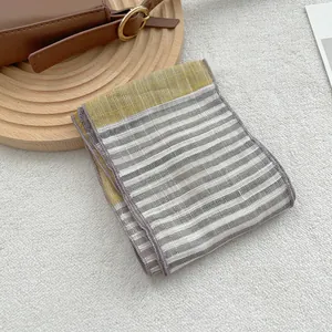 Macro shot of striped pure linen scarf detailing soft texture and fine edge stitching