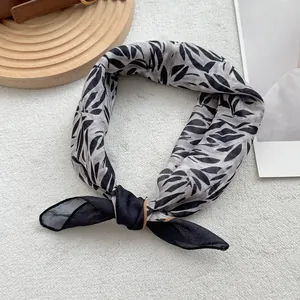 Detail of floral linen neckerchief tied in a bow on a wooden display board
