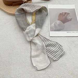 Detail of pure linen scarf with gray, white and yellow stripes and fine stitching