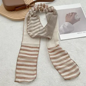 Macro detail of the lightweight beige and brown striped linen scarf with smooth hem