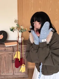 Détail de moufles d'hiver en tricot avec poignets en peluche, coloris bleu, jaune et rouge