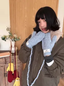 Gants en tricot torsadé bleu clair avec cordon de cou et étiquette de marque tissée