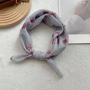 Macro detail of lightweight grey floral cotton linen scarf with elegant knot styling
