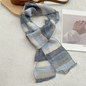 Detailed view of the pure linen scarf featuring elegant blue and gray horizontal stripes