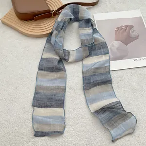 Detailed texture of striped pure linen scarf with refined stitching on grey background