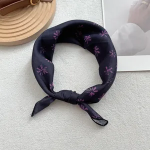 Close-up of knotted black cotton linen scarf with purple floral pattern for styling
