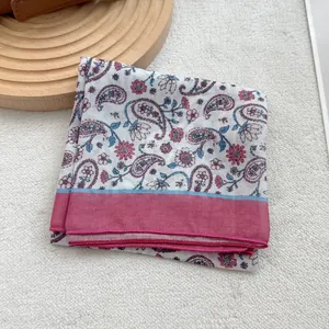 Dettaglio di un foulard a bandana con motivo paisley rosa e azzurro ripiegato