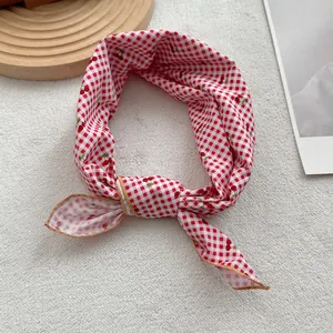 Detail of red gingham cherry scarf with exquisite gold stitched edge and soft bow knot