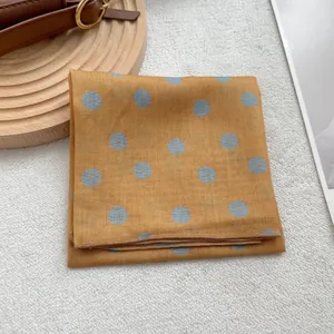Détail du foulard à pois jaunes avec motif bleu clair et couture de bord roulé
