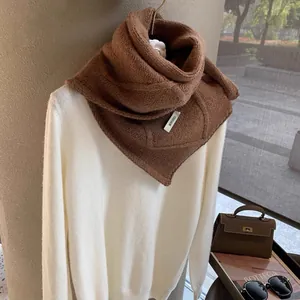 Detailed close-up of dark brown textured wool scarf with BONOGEED label and button detail
