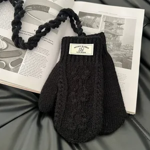 Détail de mitaines en tricot noir avec texture en laine mélangée et motifs tissés