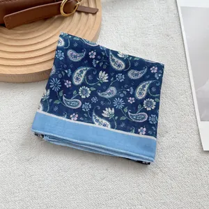 Dettaglio della sciarpa in cotone blu navy con motivi paisley e stampe floreali
