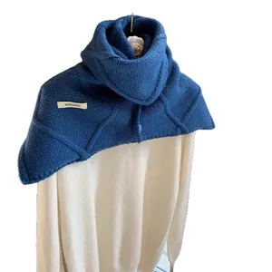 Deep blue chunky knit wool scarf with textured diamond pattern and decorative side label