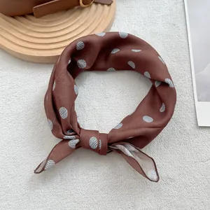 Vue détaillée d'un foulard en soie marron avec motif à pois ondulés et texture lisse