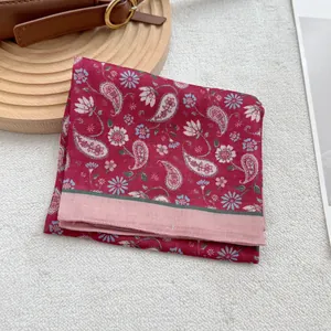Dettaglio di un foulard bordeaux in cotone e lino con motivi paisley e fiori