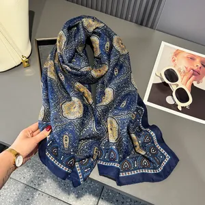 Detail of dark blue scarf with intricate paisley patterns and subtle pleated texture