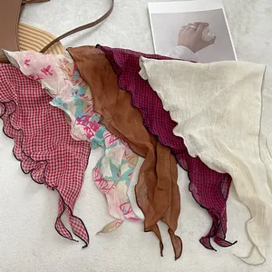 Detailed view of lightweight linen triangle scarves with various plaid and floral patterns