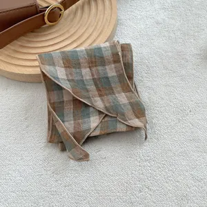 Linen checkered scarf in brown and grey blue with natural texture on soft plush background