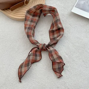 Detail of checkered orange and brown pure linen scarf texture on soft plush surface