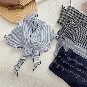 Detail of lightweight linen triangle scarves showing fine texture and hemmed edges