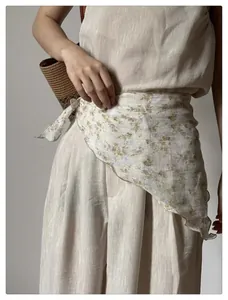 Detailed view of floral linen set with a decorative chiffon headscarf around the waist