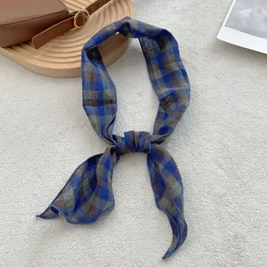 Detail of checkered pure linen scarf showing breathable weave texture and knotted design