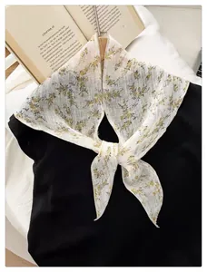 Detail of floral white chiffon triangle scarf with ties and delicate embroidery details