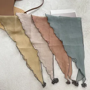 Triangle lace fashion scarves in Morandi colors with decorative pom-poms on plush background