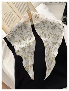 Detail of white floral triangle scarf with yellow flower print on a black sweater