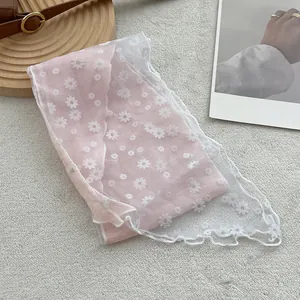 Detail van roze en witte kanten sjaal met madeliefjesprint en verfijnde golfmouwen
