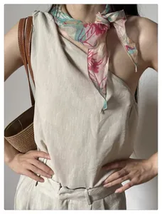 Detail of floral print scarf styled with an ivory linen one-shoulder summer set