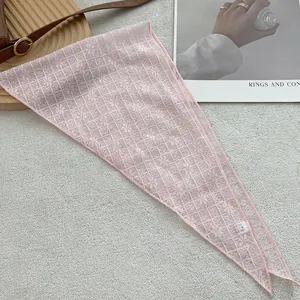 Detail shot of a pink lace triangular scarf with intricate floral hollow patterns