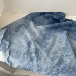 Detailed macro shot of blue and white tie-dye cotton linen fabric with fine edge stitching