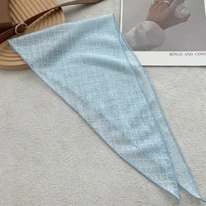 Detail of light blue floral lace triangular scarf with breathable mesh texture and neat edges