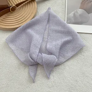 Close-up of light purple lace scarf with intricate hollow floral patterns and elegant texture