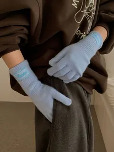 Detail of light blue knitted wool gloves with ribbed windproof cuffs and woven brand label