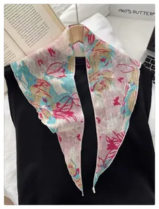 Floral print narrow silk scarf draped on a wooden hanger with a vintage French aesthetic