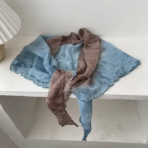 Detail of tie-dye cotton linen scarf with blue and brown gradients and ruffled edges