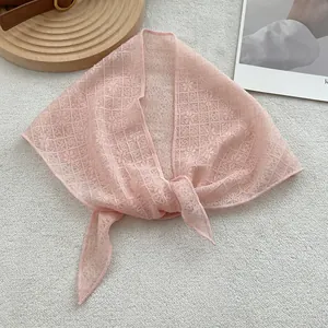 Detailed close-up of light pink lace triangular scarf with elegant floral patterns