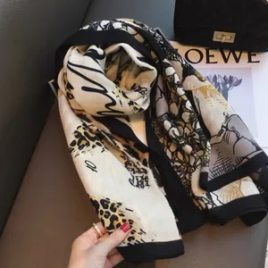 Detail of cotton linen scarf featuring leopard print and hand-drawn patterns on dark leather