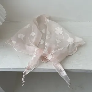 Detailopname van crème kanten sjaal met bloemmotieven en een fijne afwerking van de zoom