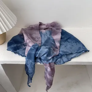 Detailed view of tie-dye scarf featuring purple and blue gradients and ruffled knit edges