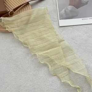 Close-up of light yellow linen triangle scarf with textured stripes and wavy edges